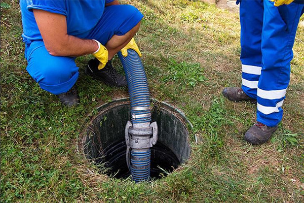 Technici legen een septische put met professionele zuigslang